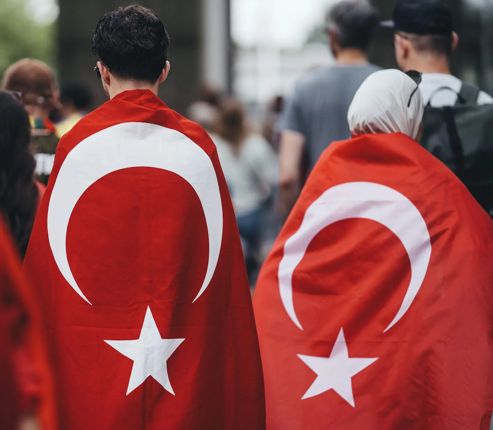 Football fans wearing Turkey flag body flags as capes