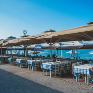 Beige patio umbrellas along a seaside promenade