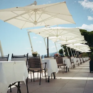 White cantilever patio umbrellas at a seaside restaurant