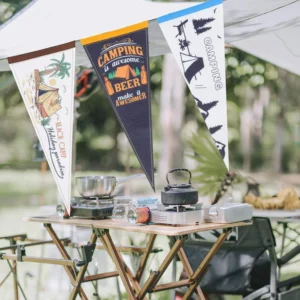 Custom camping pennant flags hanging at a campsite