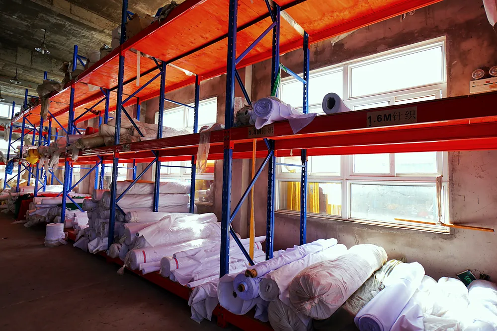 Rolls of knitted flag fabric on racks labeled 1.4M and 1.6M knitted in the Senior Flags fabric store, Lu'an