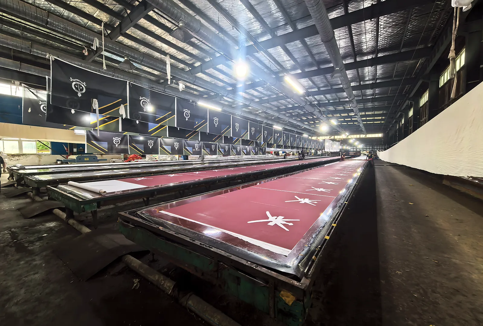 Long screen printing tables with flags being printed in the Senior Flags factory
